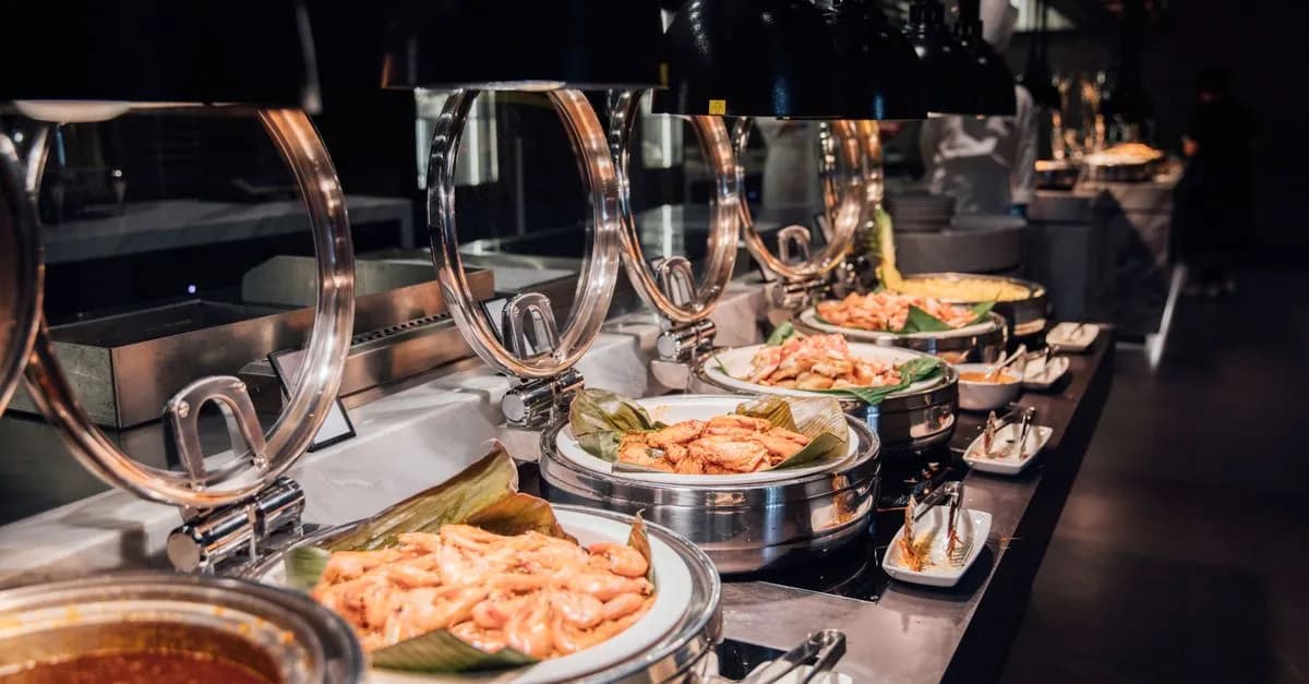 A tempting display of a luxurious buffet with various prepared dishes under warm lighting.
