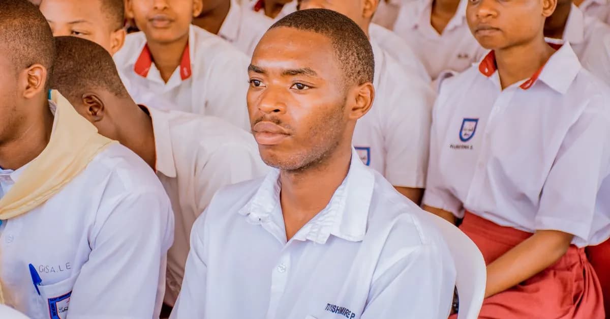 A group of students attending a lecture wearing school uniforms, focused and attentive.