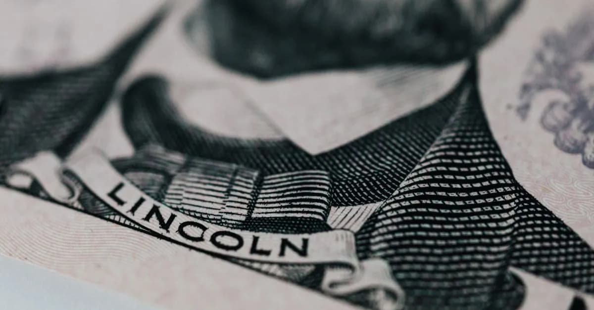 Crop of five dollar banknote with president Lincoln wearing costume on table